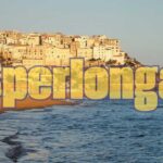 Giocatore festante con biglietto vincente del Superenalotto in mano.