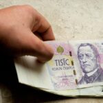 Immagine di un pensionato sorridente mentre controlla il proprio estratto conto bancario.