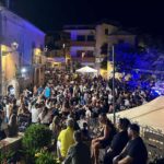 Immagine di un concorrente di Affari Tuoi mentre gioca con i pacchi sul tavolo.