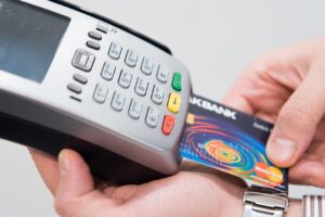 Immagine che illustra il pagamento contactless con carta e smartphone, evidenziando i potenziali rischi.