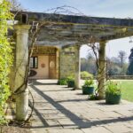 Pergolato coperto di piante rampicanti fiorite, ideale per ombra e decorazione esterna.